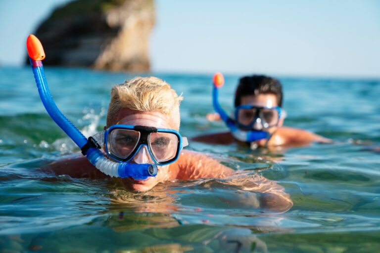 Two people in the water wearing snorkeling masks.